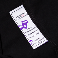 Inside of black tee with washtag showing details about the Carpet film BRAT