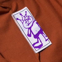 Brown tee's wash label with purple character 