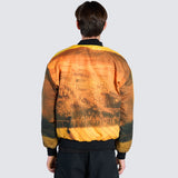 Back of a Male wearing orange bomber jacket with cartoon imagery